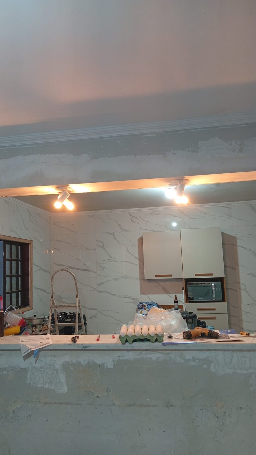 Cozinha com sanca de gesso e revestimento em mármore